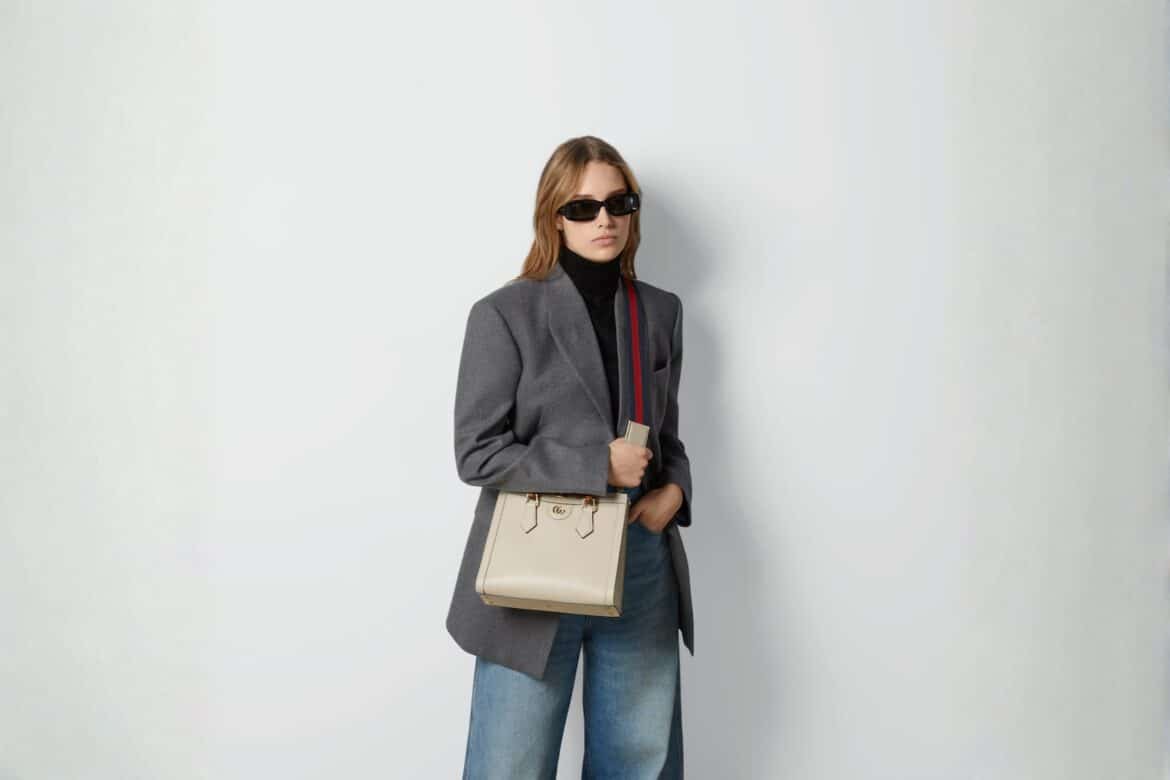 Person holding a stylish Gucci DIana handbag.