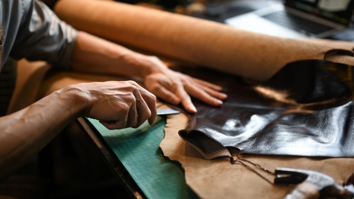 Person crafting leather on workspace