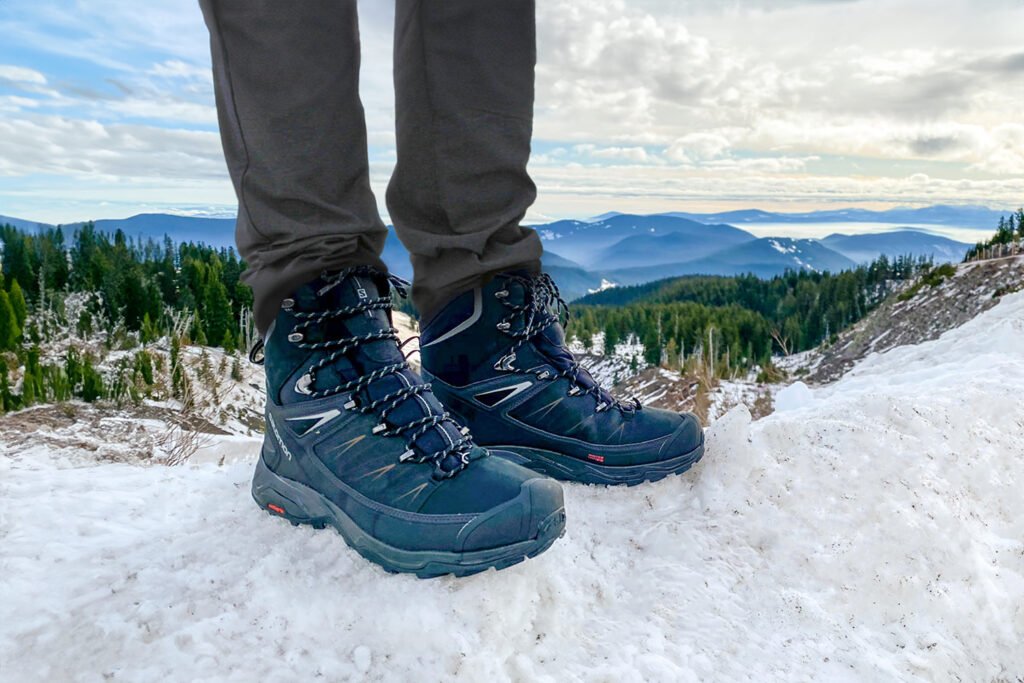 Men's boots on snowy mountain terrain