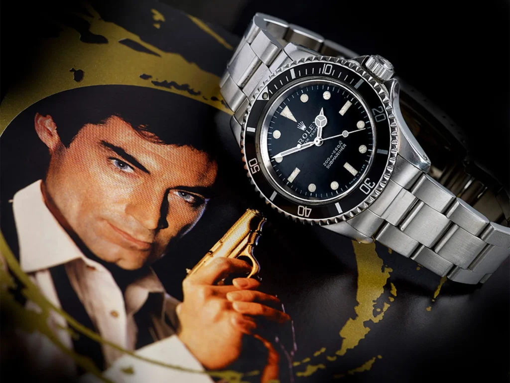 Rolex Submariner dive watch displayed beside a James Bond image, highlighting the iconic steel sports watch.