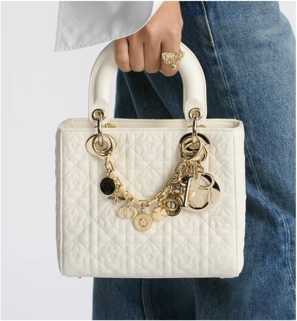 White Lady Dior handbag with gold charms and quilted leather design.