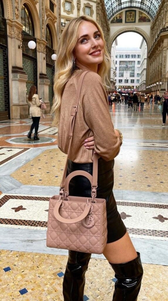 Woman carrying a blush pink Lady Dior handbag inside a historic Milan shopping arcade.