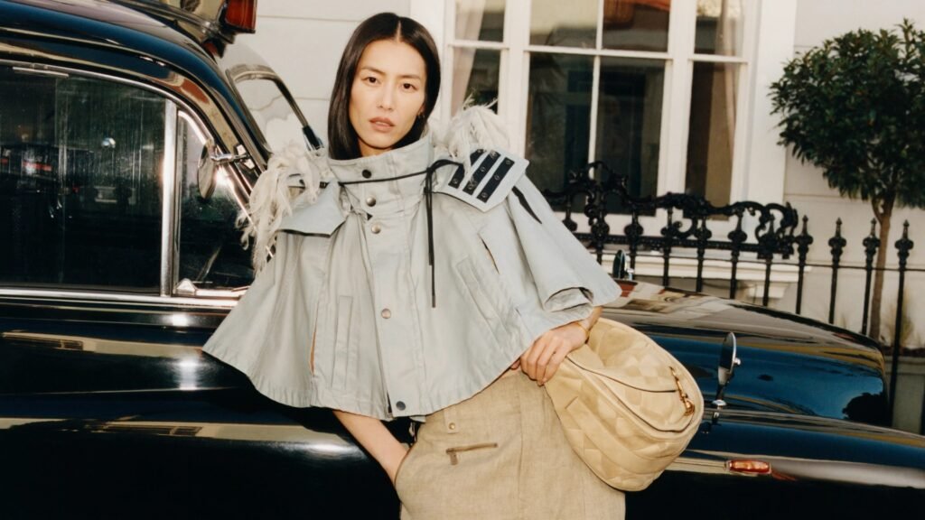 Fashionable Burberry model beside vintage car.