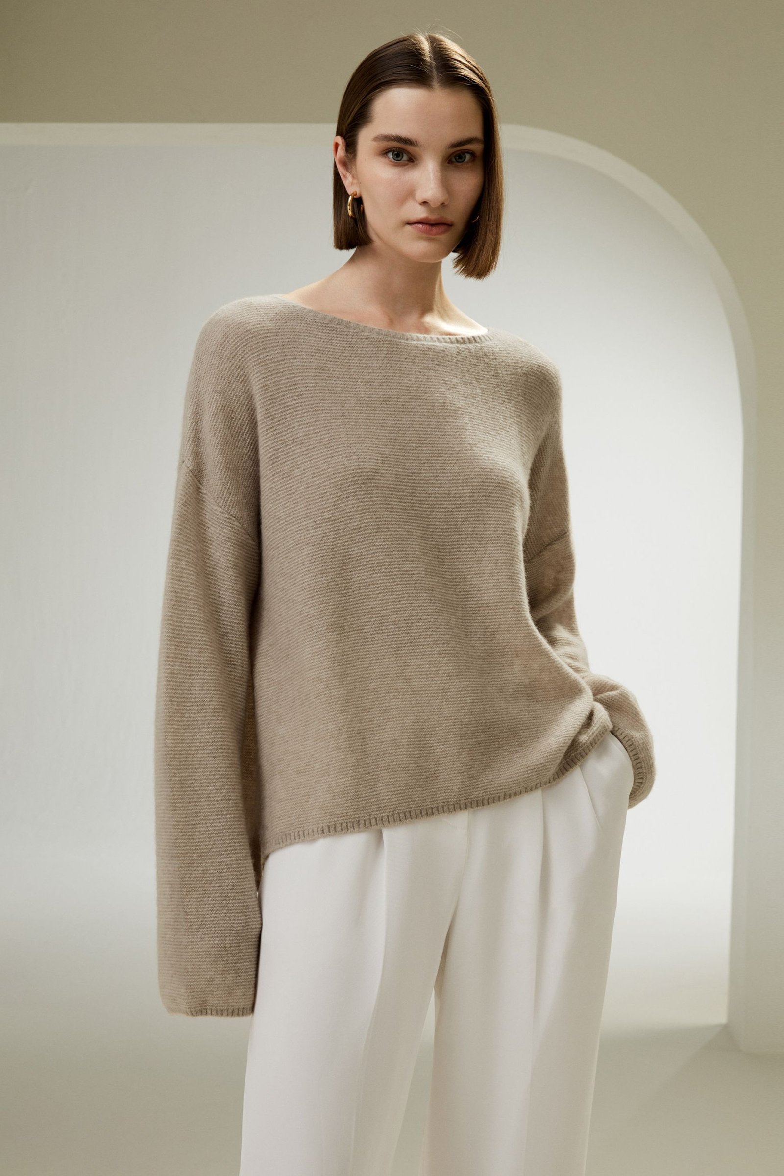 Model wearing a relaxed silk and cashmere sweater with tailored trousers