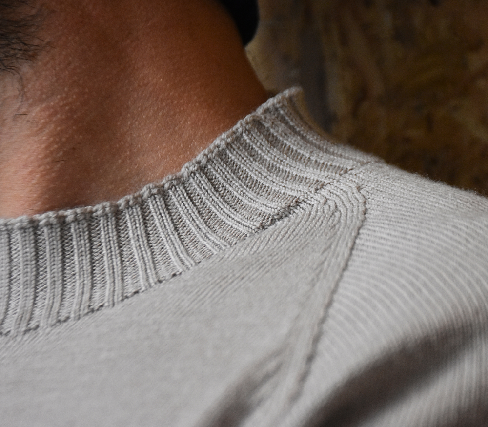Close-up of a shaped shoulder seam and ribbed merino sweater neckline