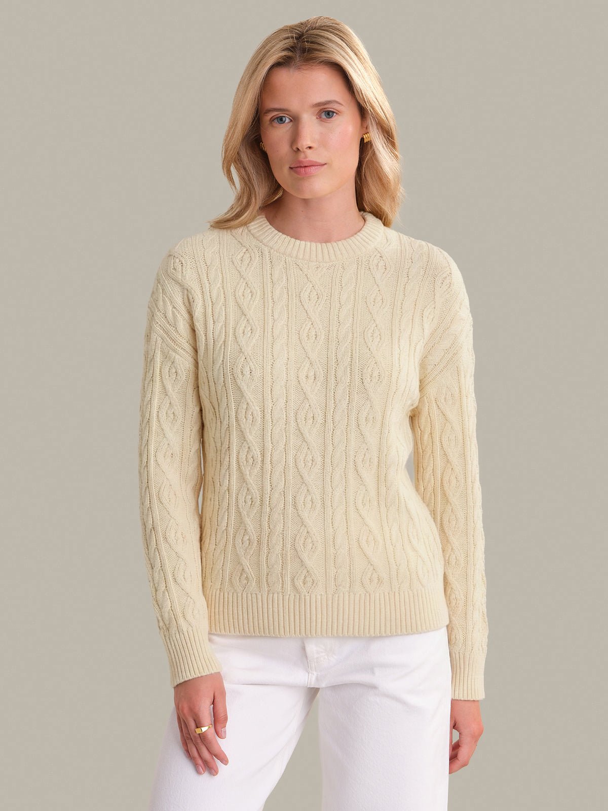 Model wearing a textured cotton cable-knit crewneck sweater