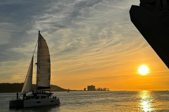 Luxury catamaran sailing on the Tagus River at sunset
