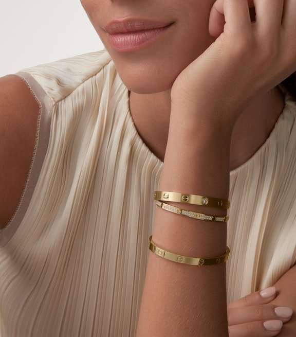 Stacked Cartier Love Bracelets fitted closely around the wrist.