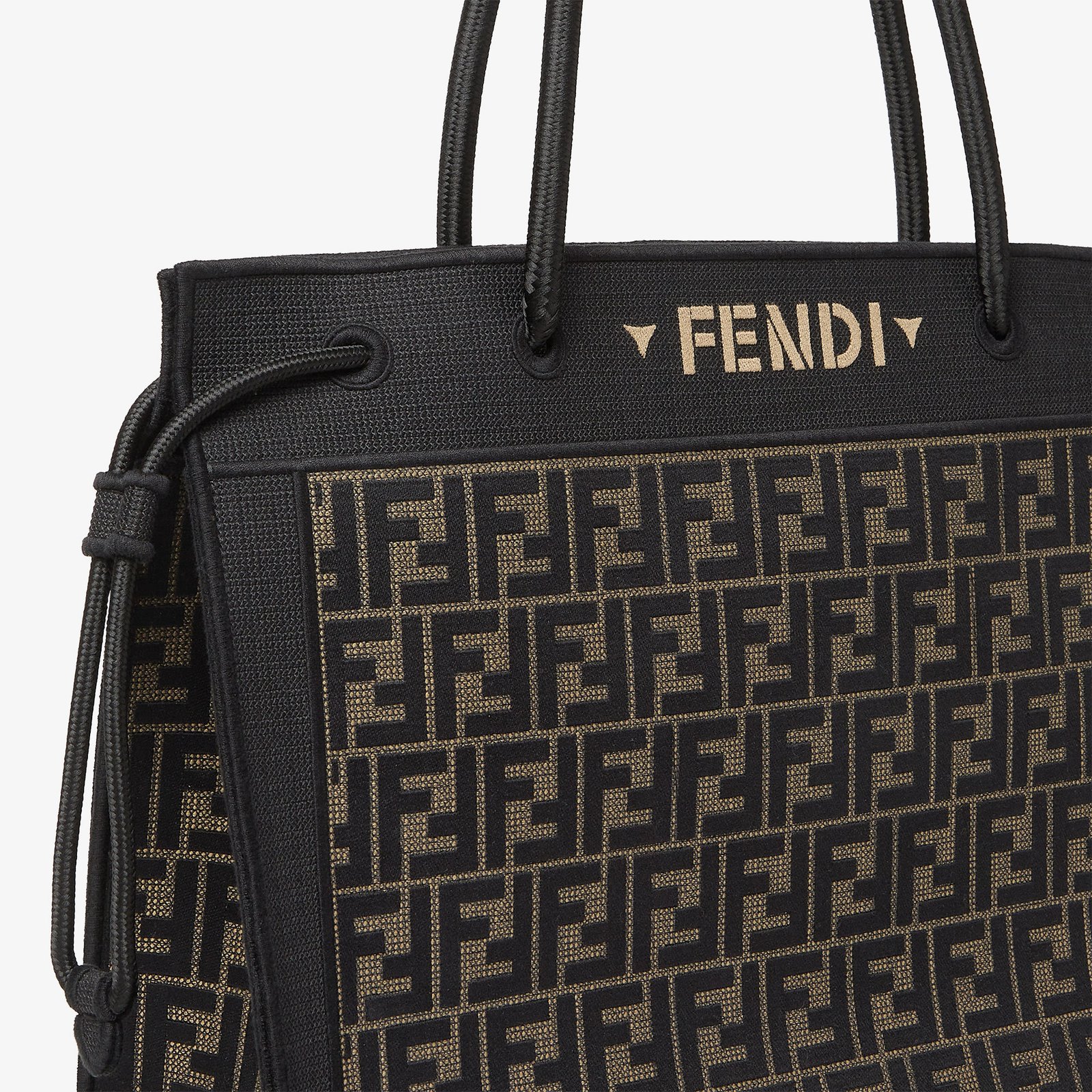 Close-up of brown FF embroidery, black cord handle and side drawstring on a Fendi Magic Shopper.