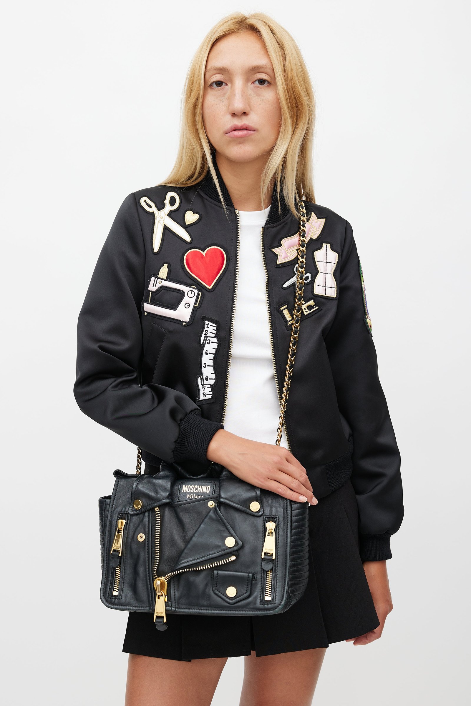 Black Moschino Biker Jacket Bag with gold hardware in an editorial setting.
