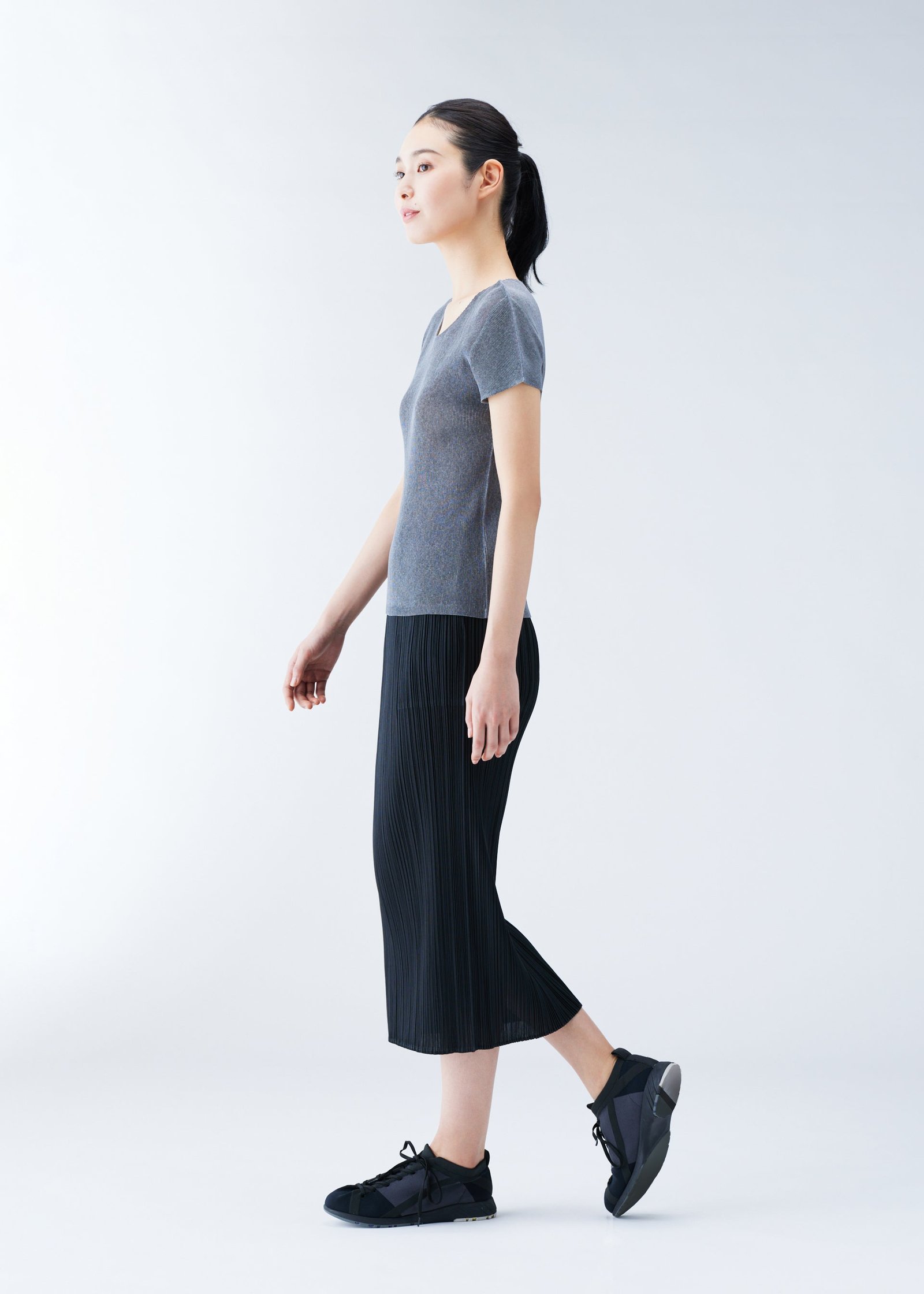 Model wearing a lightweight Pleats Please Issey Miyake top and skirt