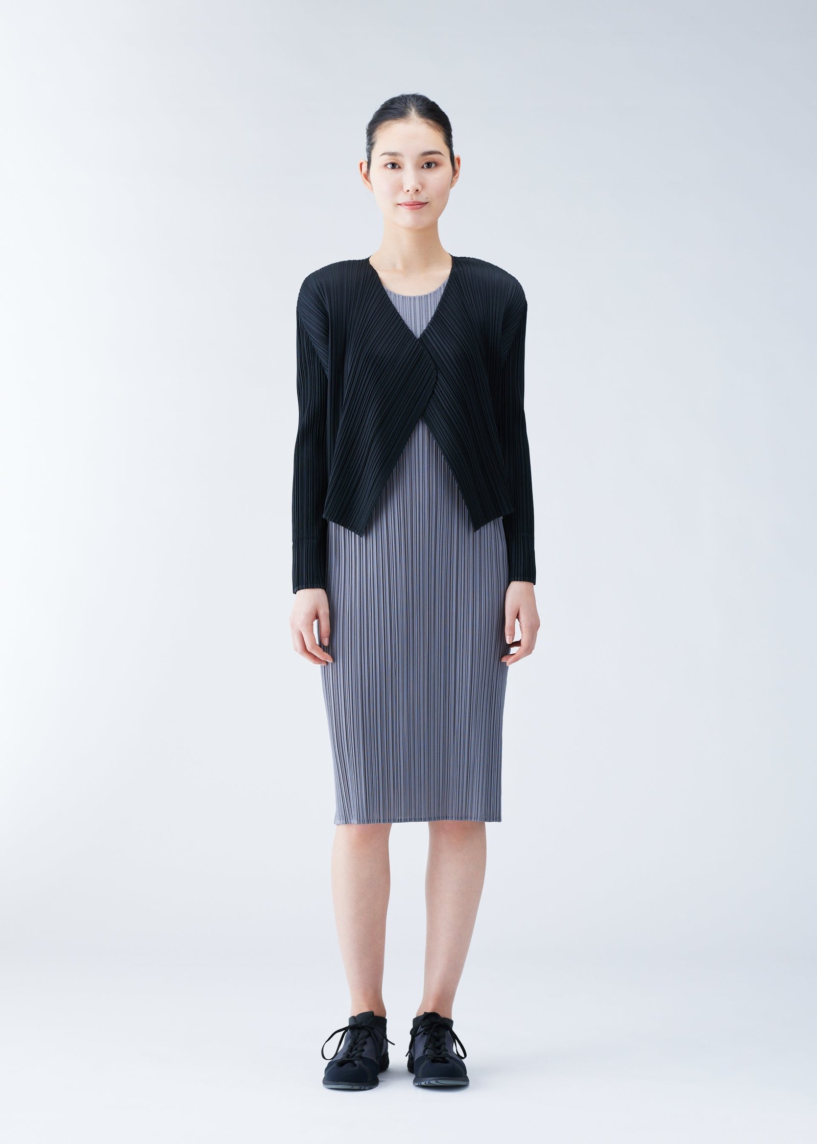 Model styling Pleats Please Issey Miyake layers in black and grey