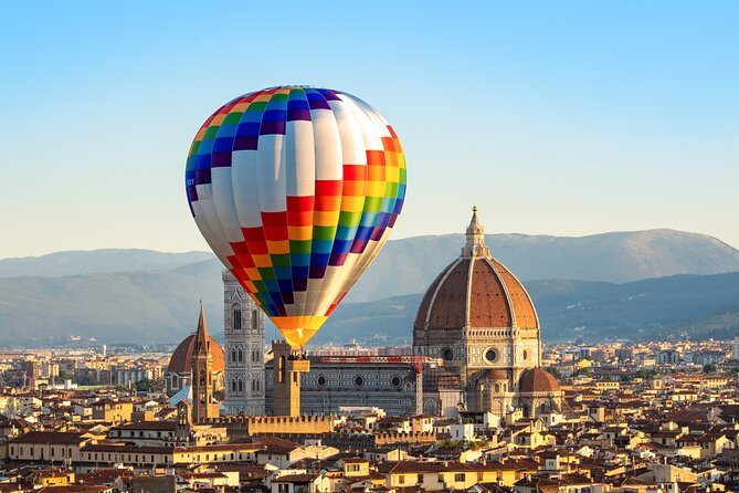 Hot air balloon flying above Florence at sunrise