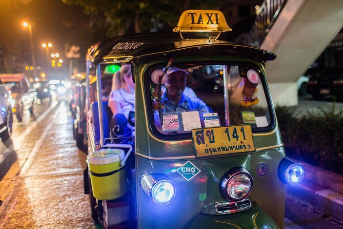 Bangkok tuk-tuk travelling through the illuminated city at night