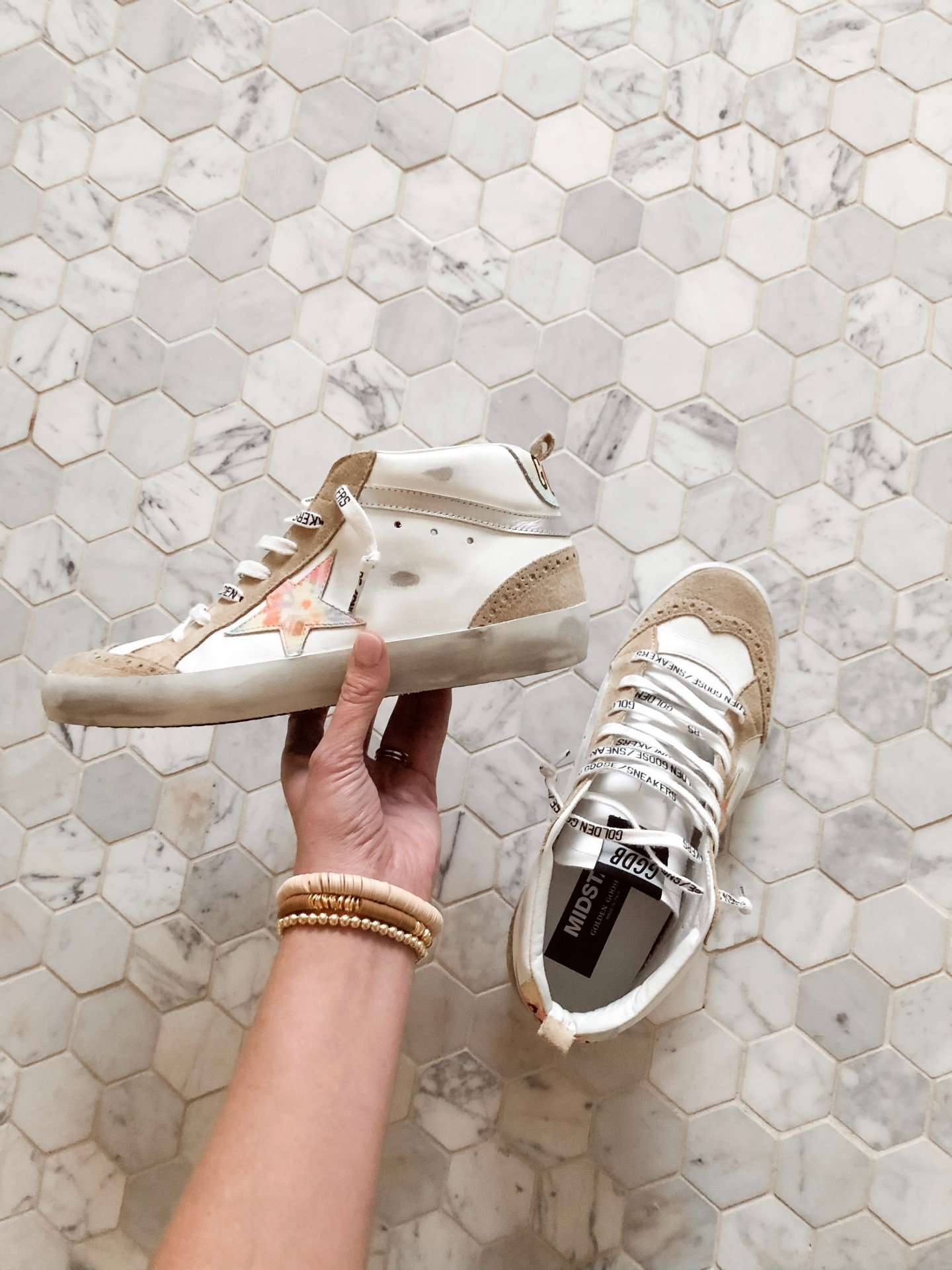 Golden Goose sneakers worn while seated on outdoor steps