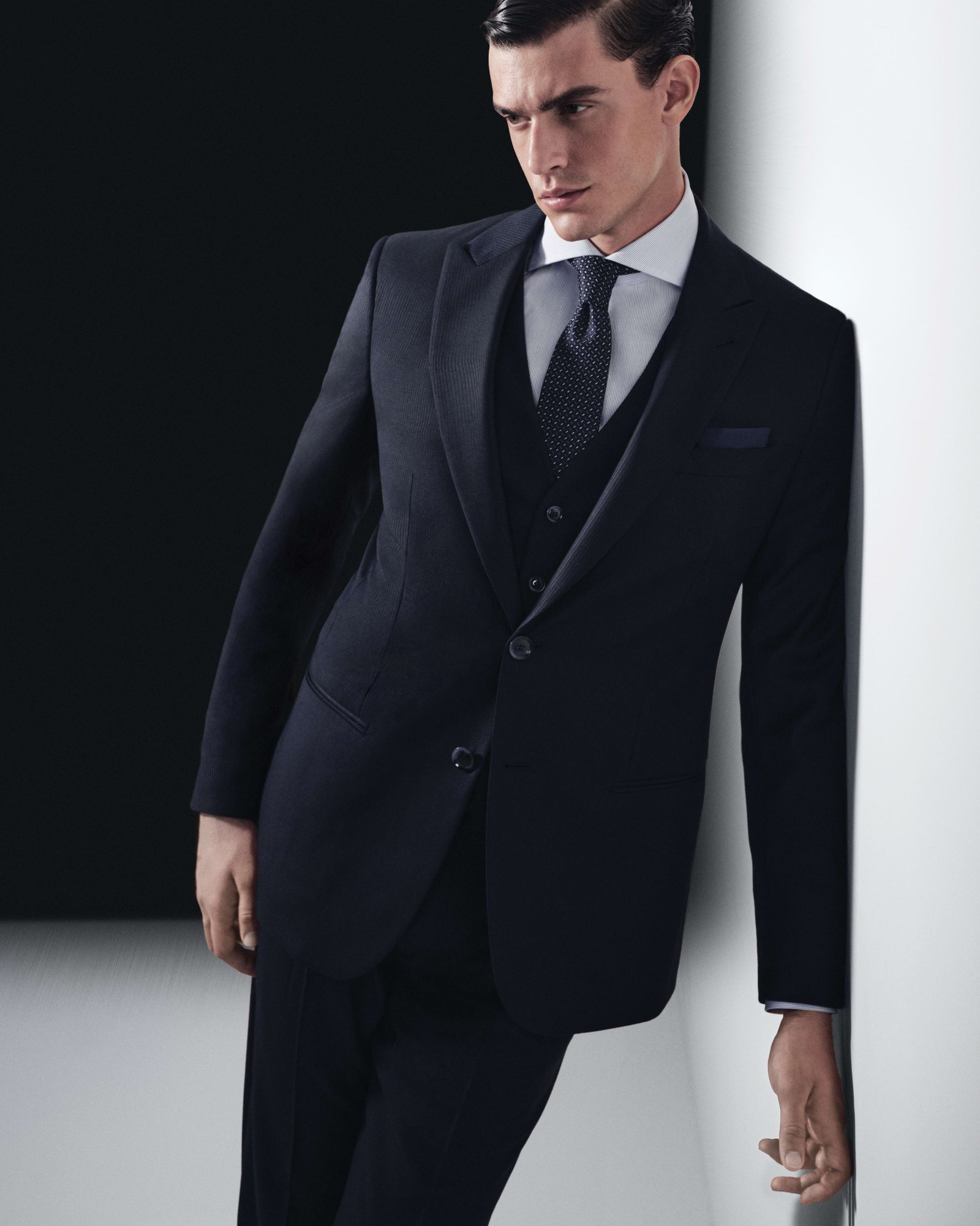 Model wearing a navy Giorgio Armani three-piece suit.