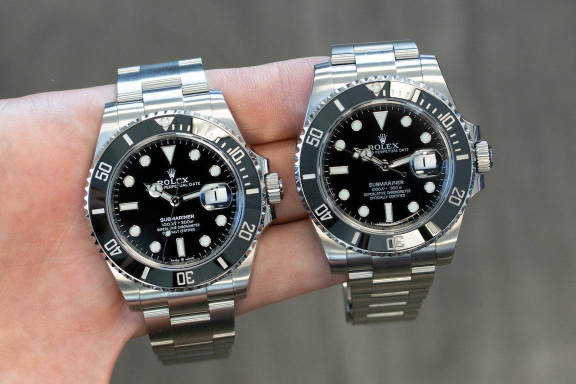 Rolex Submariner 124060 and Submariner Date 126610LN compared by hand.