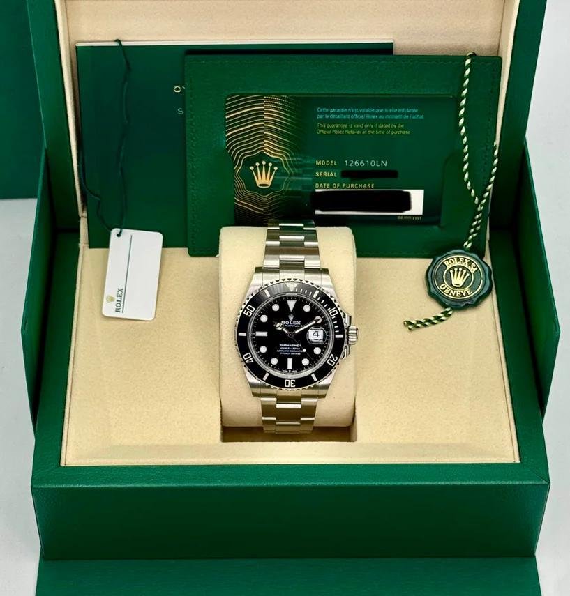 Rolex Submariner presented with its box, warranty card and accessories.