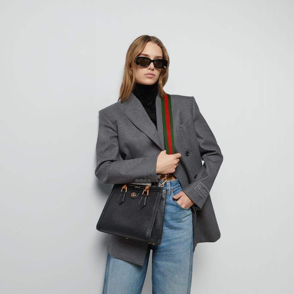 Model carrying a black Gucci Diana tote to show its proportions.