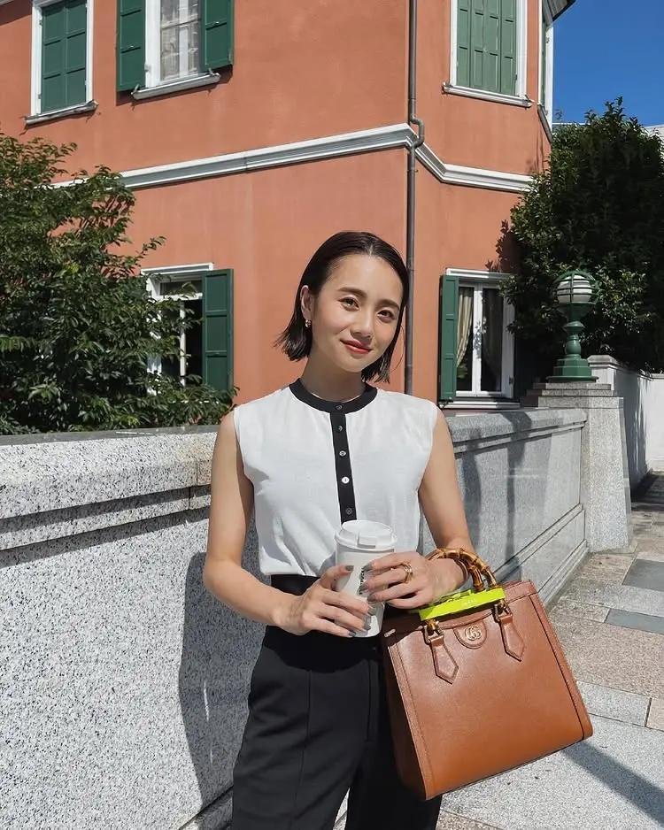 Model styling a brown Gucci Diana bag with an elevated casual outfit.