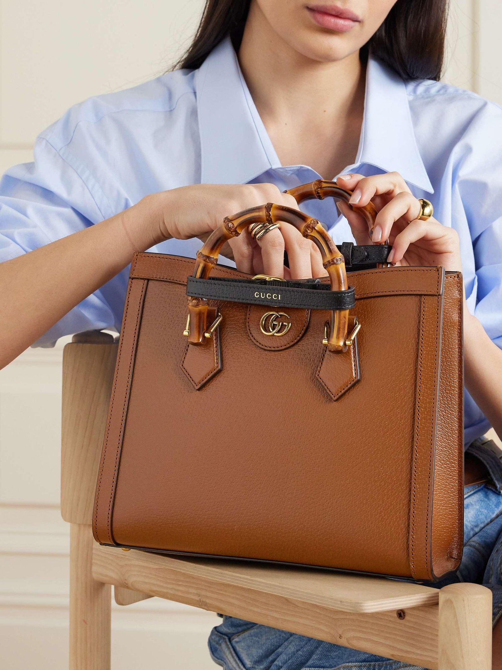Model carrying a cuir brown Gucci Diana bag.