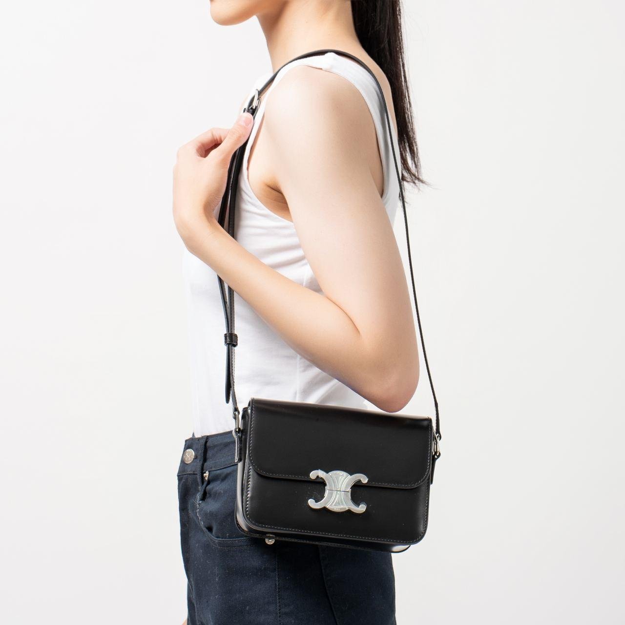 Model holding two Celine Triomphe bags to compare their proportions.