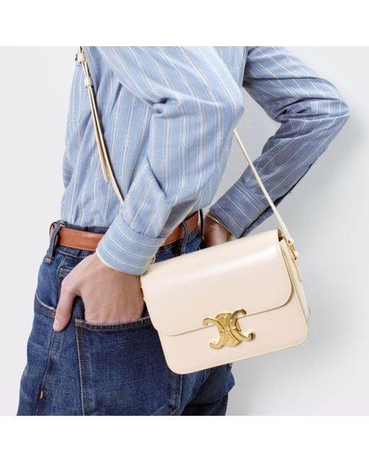 Model carrying a light Celine Triomphe bag to demonstrate its scale.