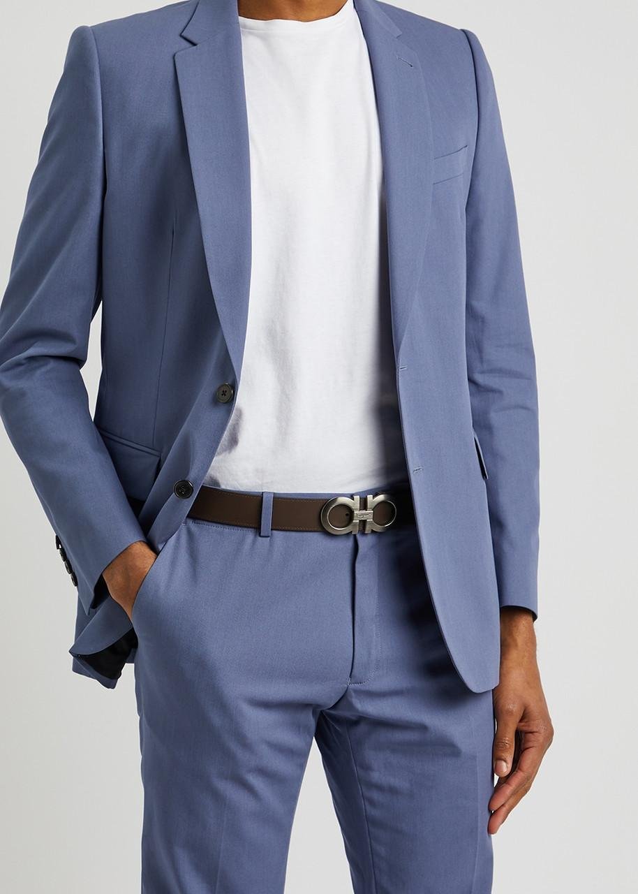 Man wearing a Ferragamo belt with a light blue suit and white shirt.