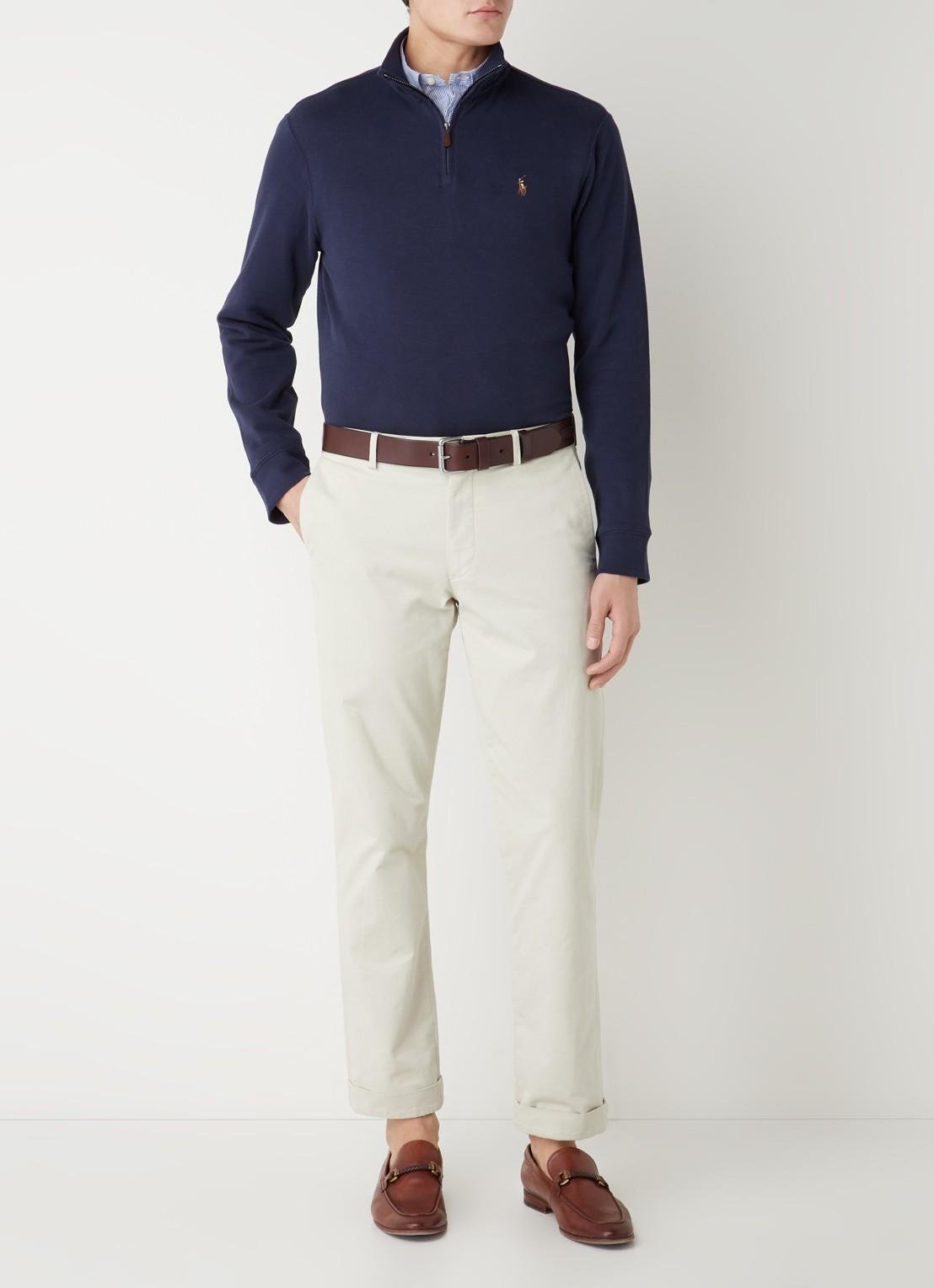 Model styling a Ralph Lauren quarter-zip with classic casual trousers.