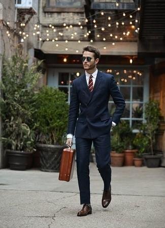Model styling Berluti dress shoes with a tailored navy suit.