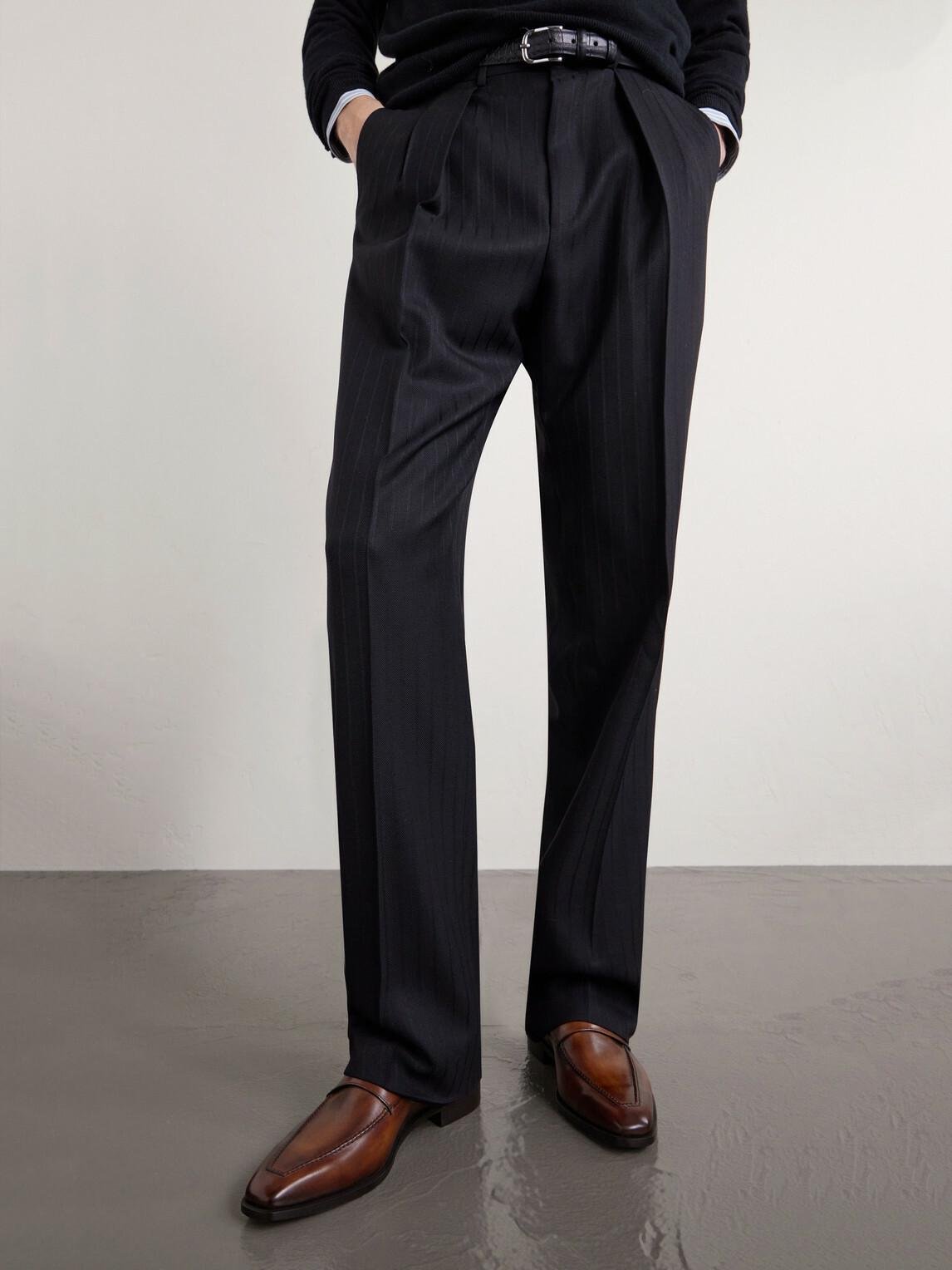 Model wearing polished brown Berluti shoes with tailored black trousers.