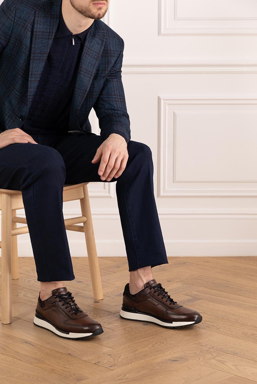 Model wearing brown Berluti sneakers with a dark tailored outfit.