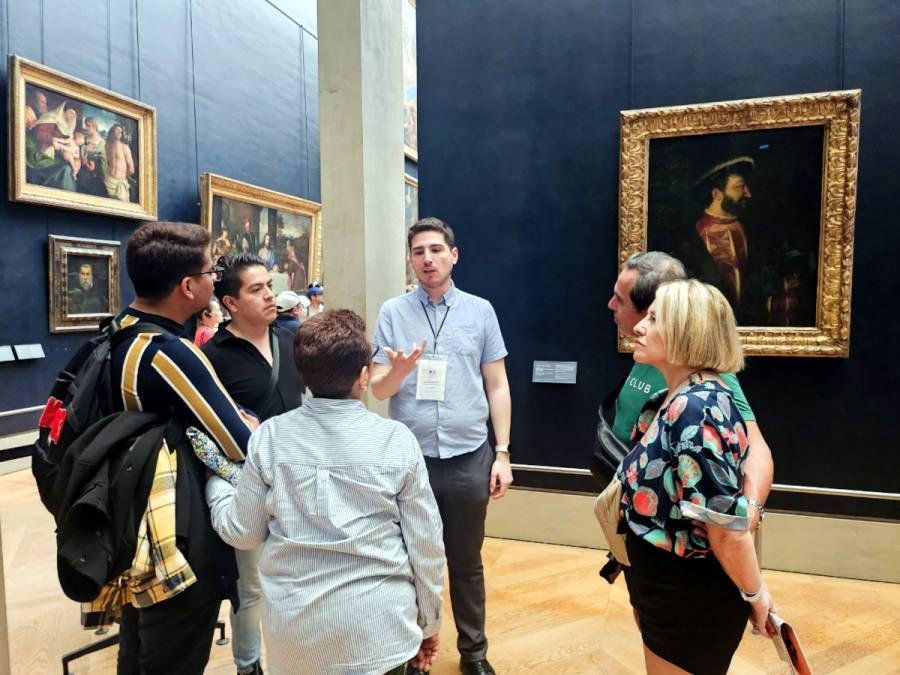 Guide leading a small group through a Louvre gallery.