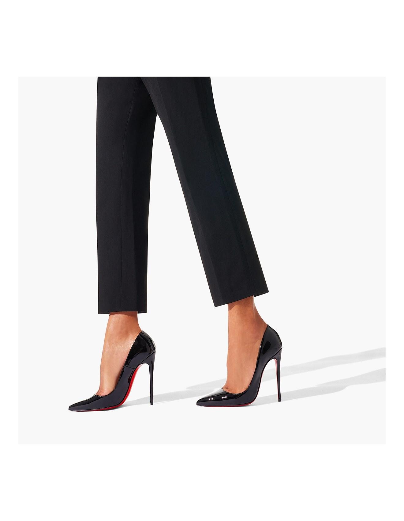 Black Christian Louboutin pumps worn with cropped tailored trousers.