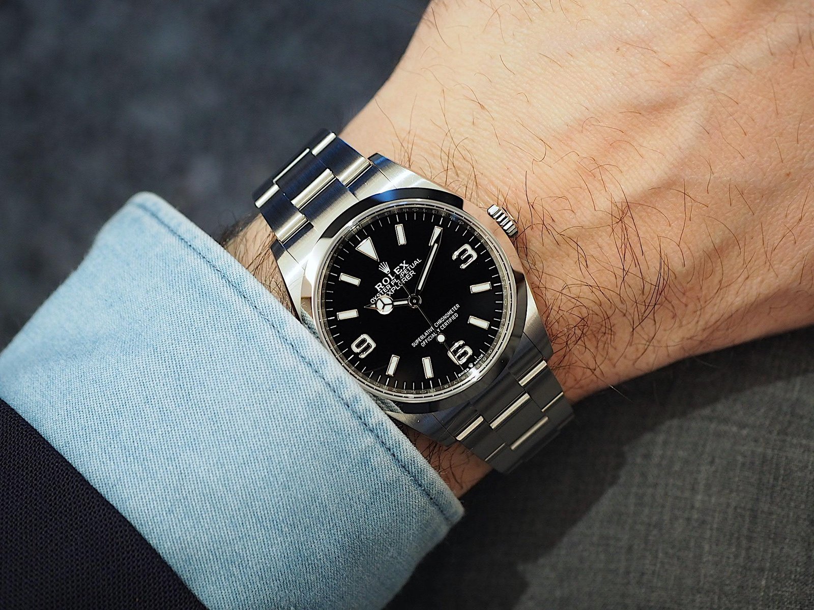 Earlier-generation steel Rolex watch with a black dial worn on the wrist.