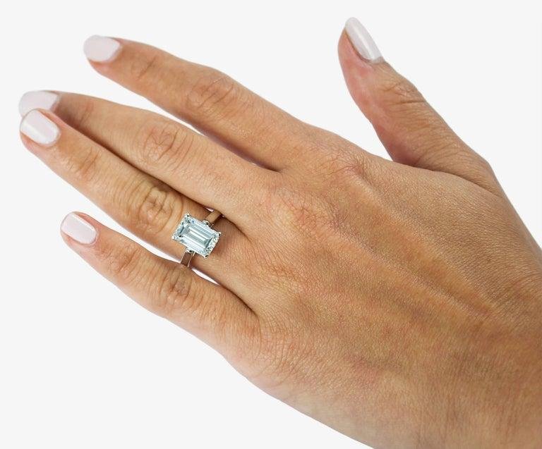 Emerald-cut Tiffany engagement ring worn on the hand.