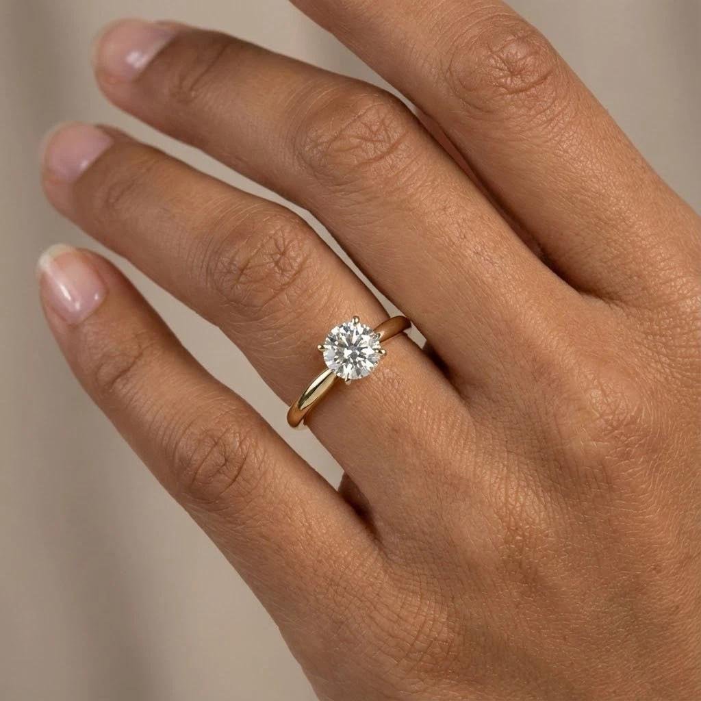 Tiffany Setting diamond engagement ring worn on the hand.