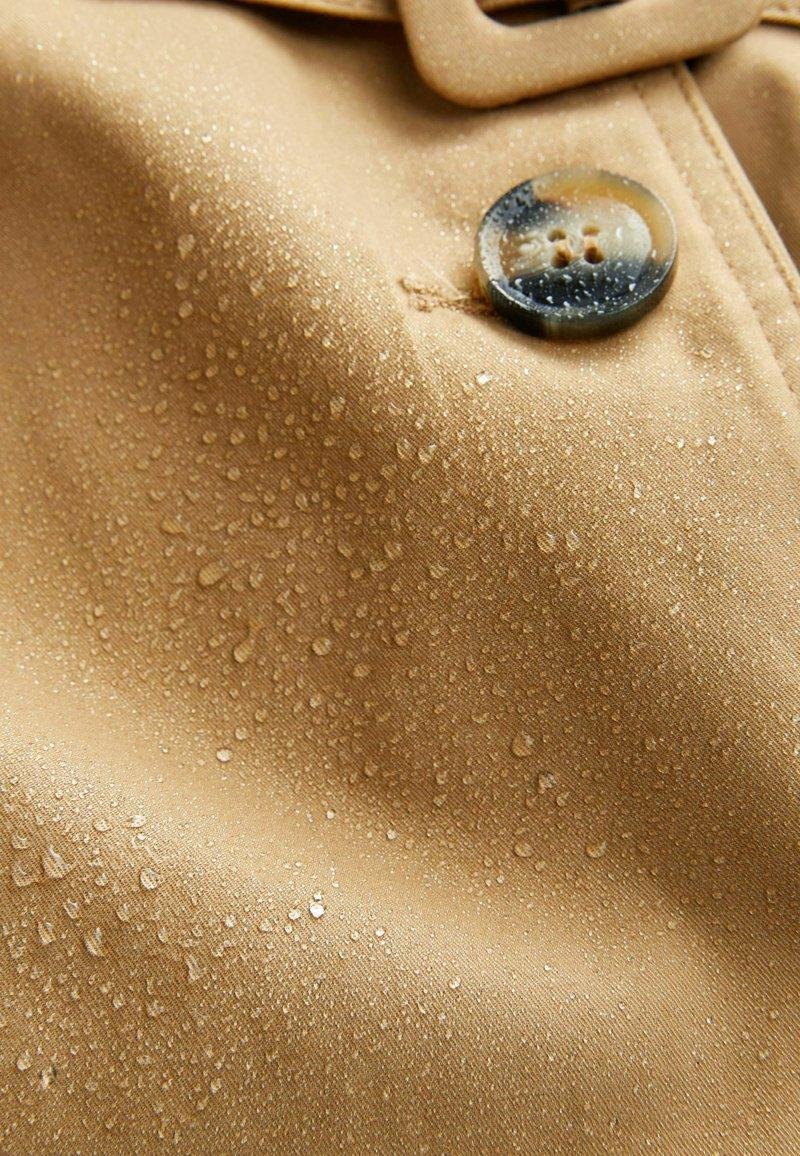Water droplets beading on Burberry cotton gabardine.