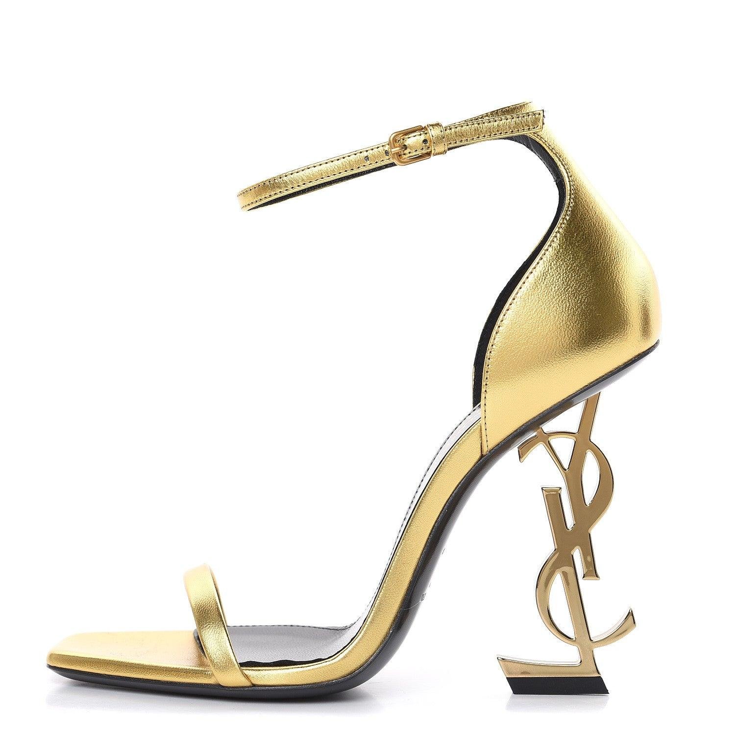 Gold Saint Laurent Opyum ankle-strap sandal with sculptural logo heel.