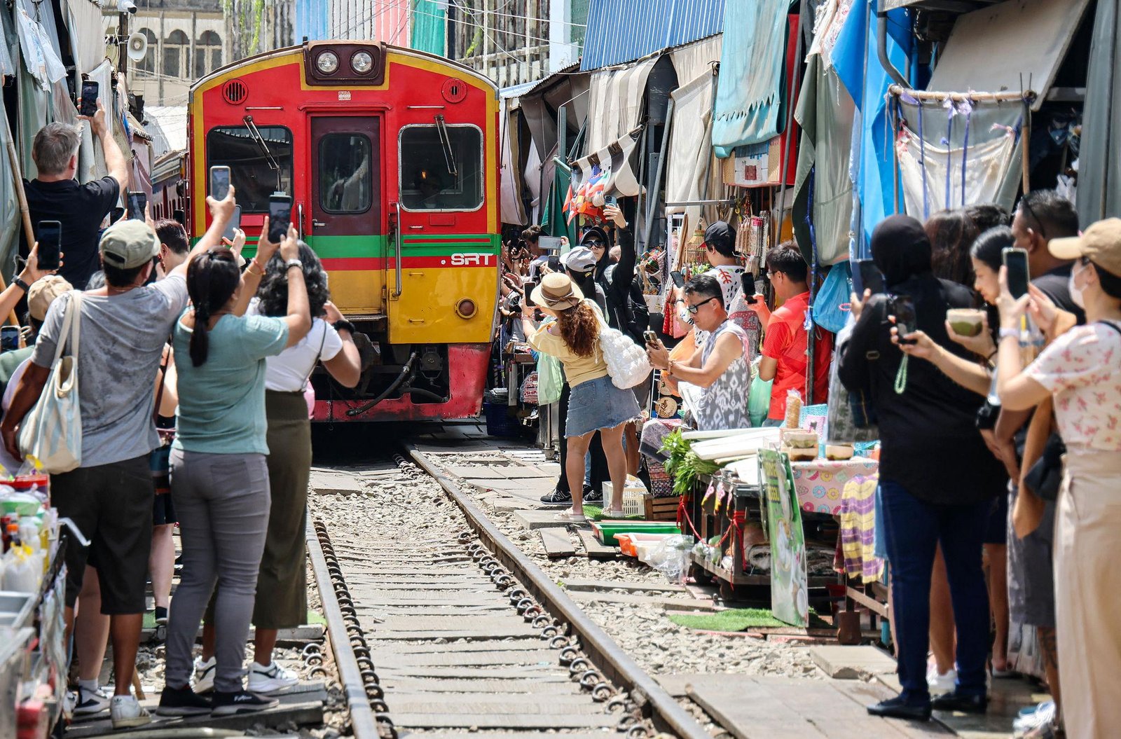 Visitors waiting for the train at Maeklong Railway Market.