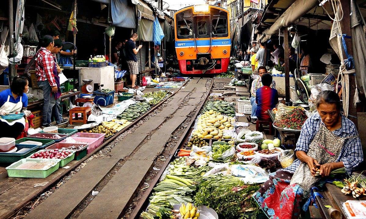 Vendors and train sharing the market space at Maeklong.