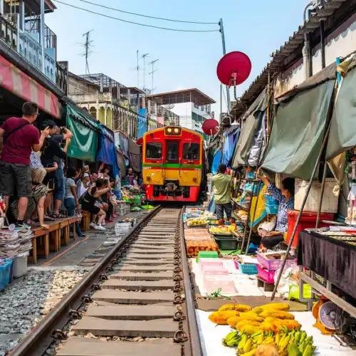 Colourful market stalls surrounding the railway at Maeklong.