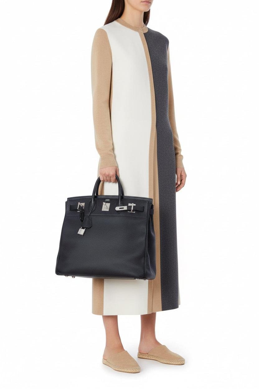 Model carrying a black Hermès Birkin bag.