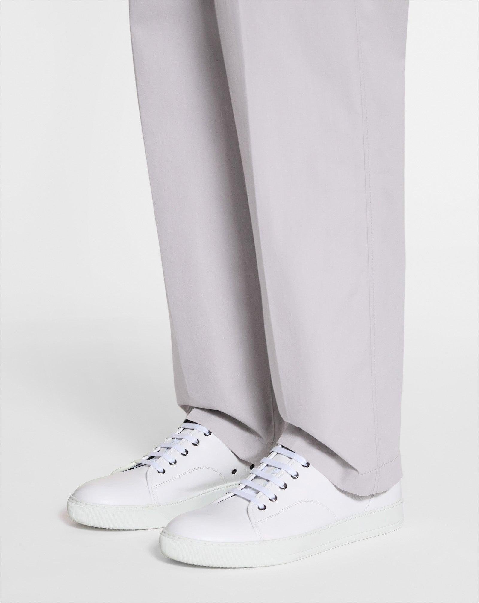 White Lanvin DBB1 sneakers worn with wide-leg trousers