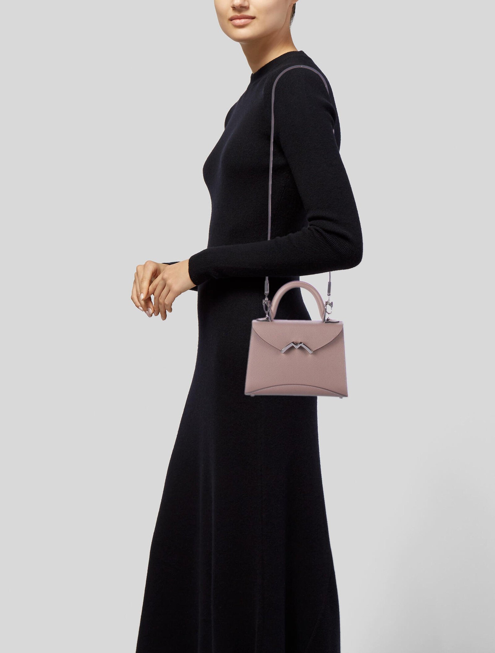 Model wearing a compact Moynat Gabrielle bag with a black dress.
