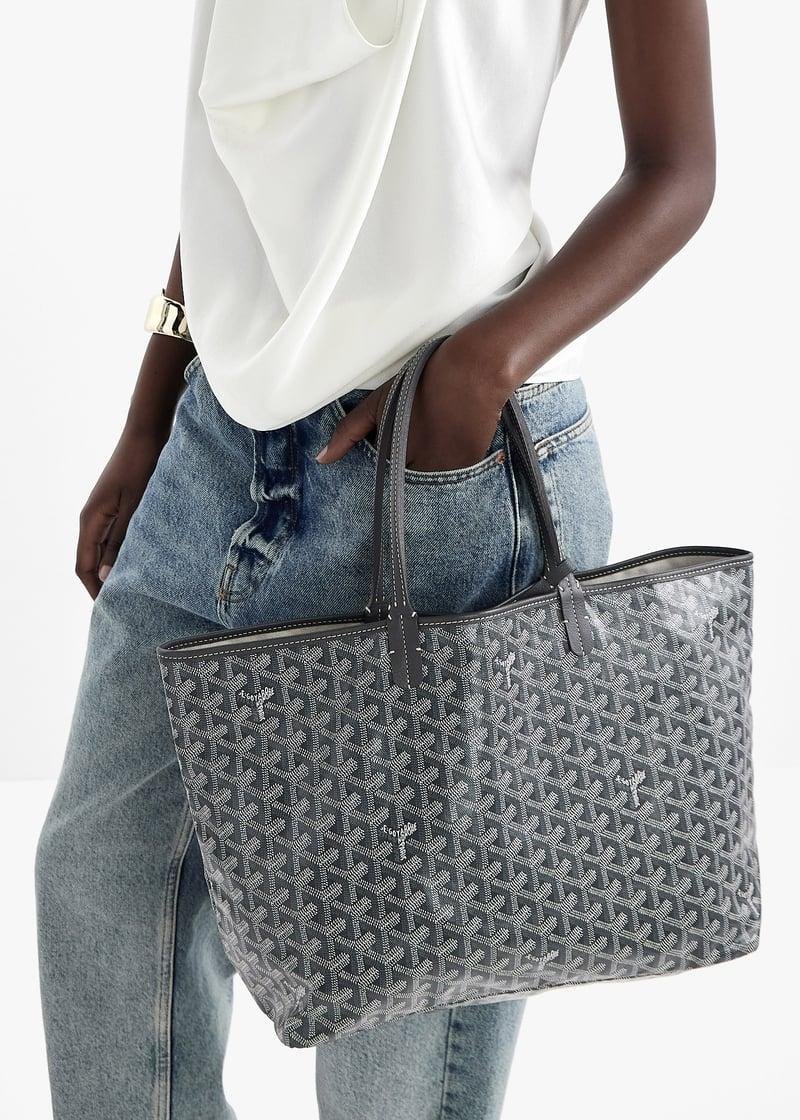 Woman carrying a grey Goyard Saint Louis tote in patterned Goyardine canvas.