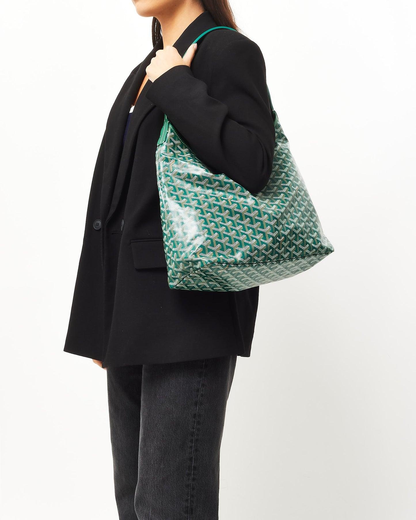Woman carrying a green Goyard Bohème Hobo bag over the shoulder.