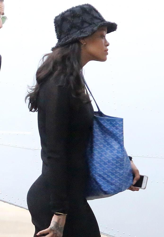 Woman carrying a blue Goyard Saint Louis tote with a monochrome outfit.