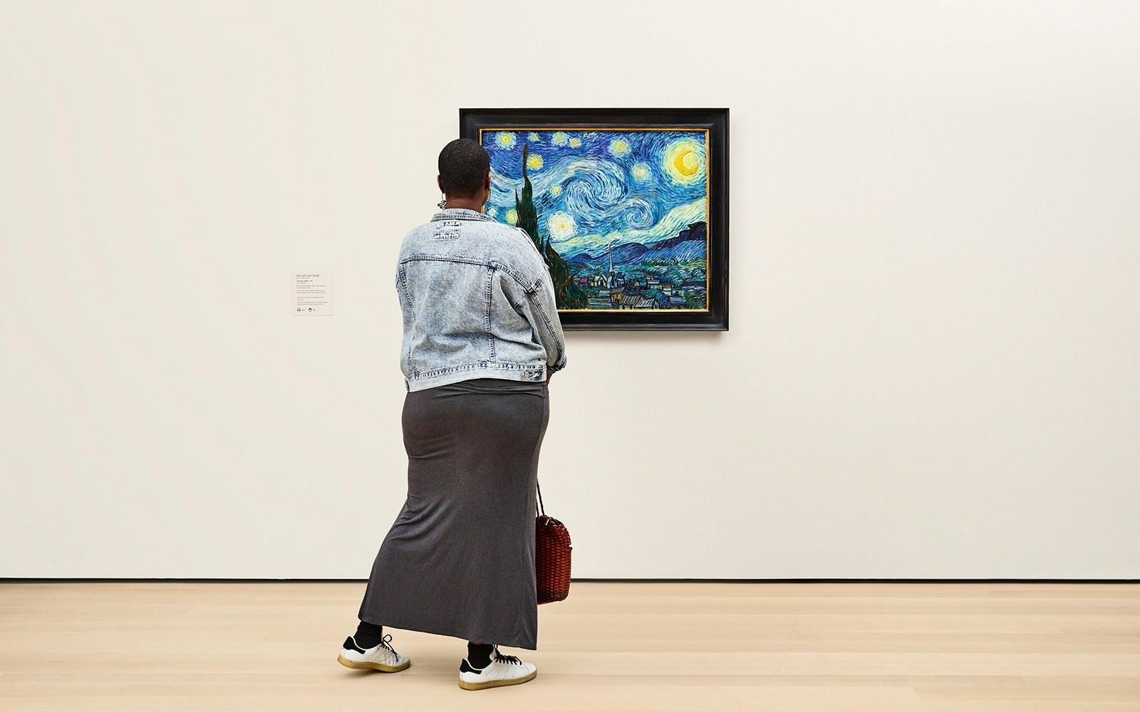 Visitor examining a painting inside MoMA