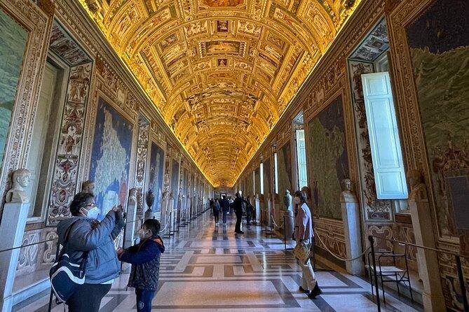 Visitors walking through the Gallery of Maps in appropriate attire.